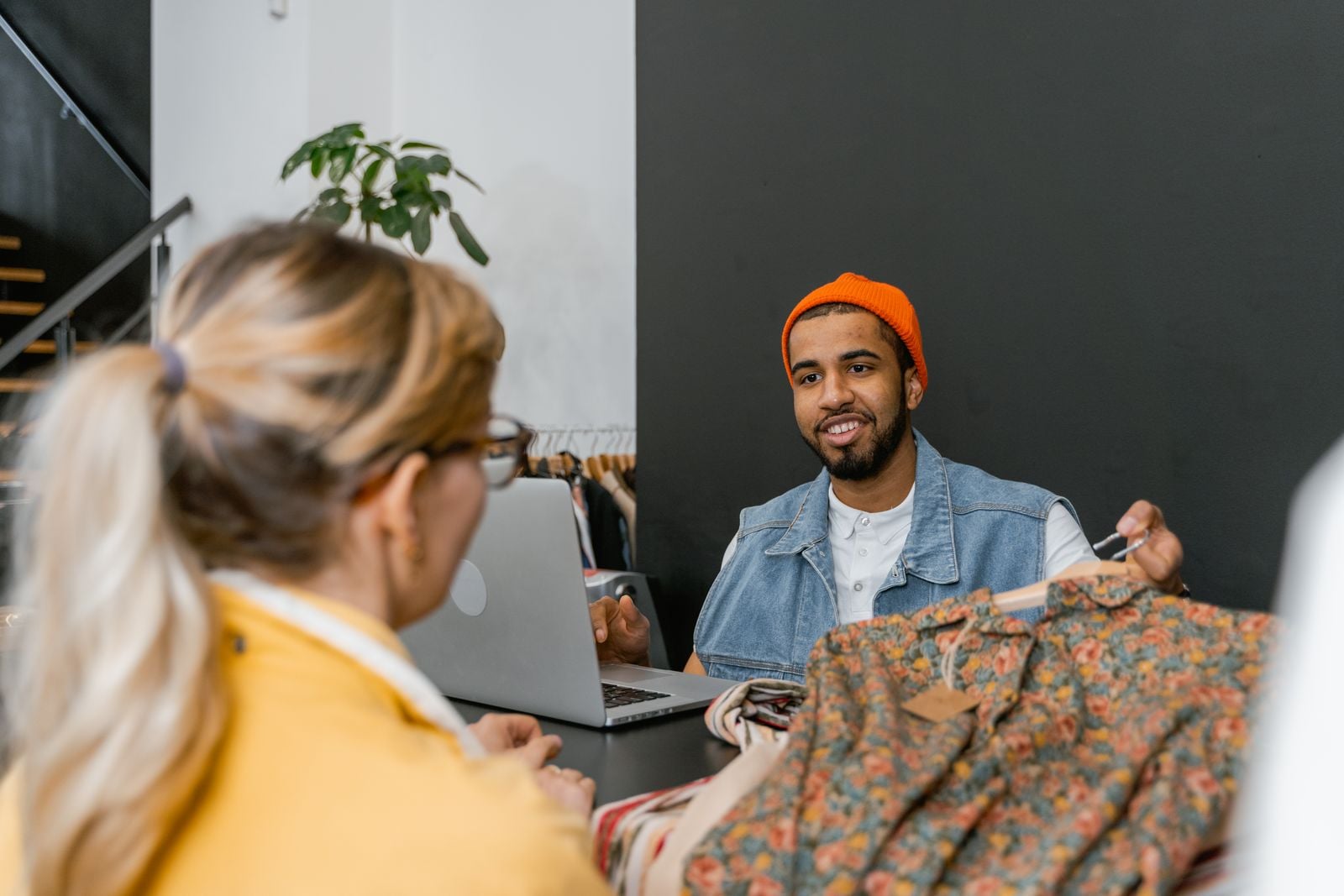 Conversation entre une cliente et un commerçant derrière le comptoir de sa boutique