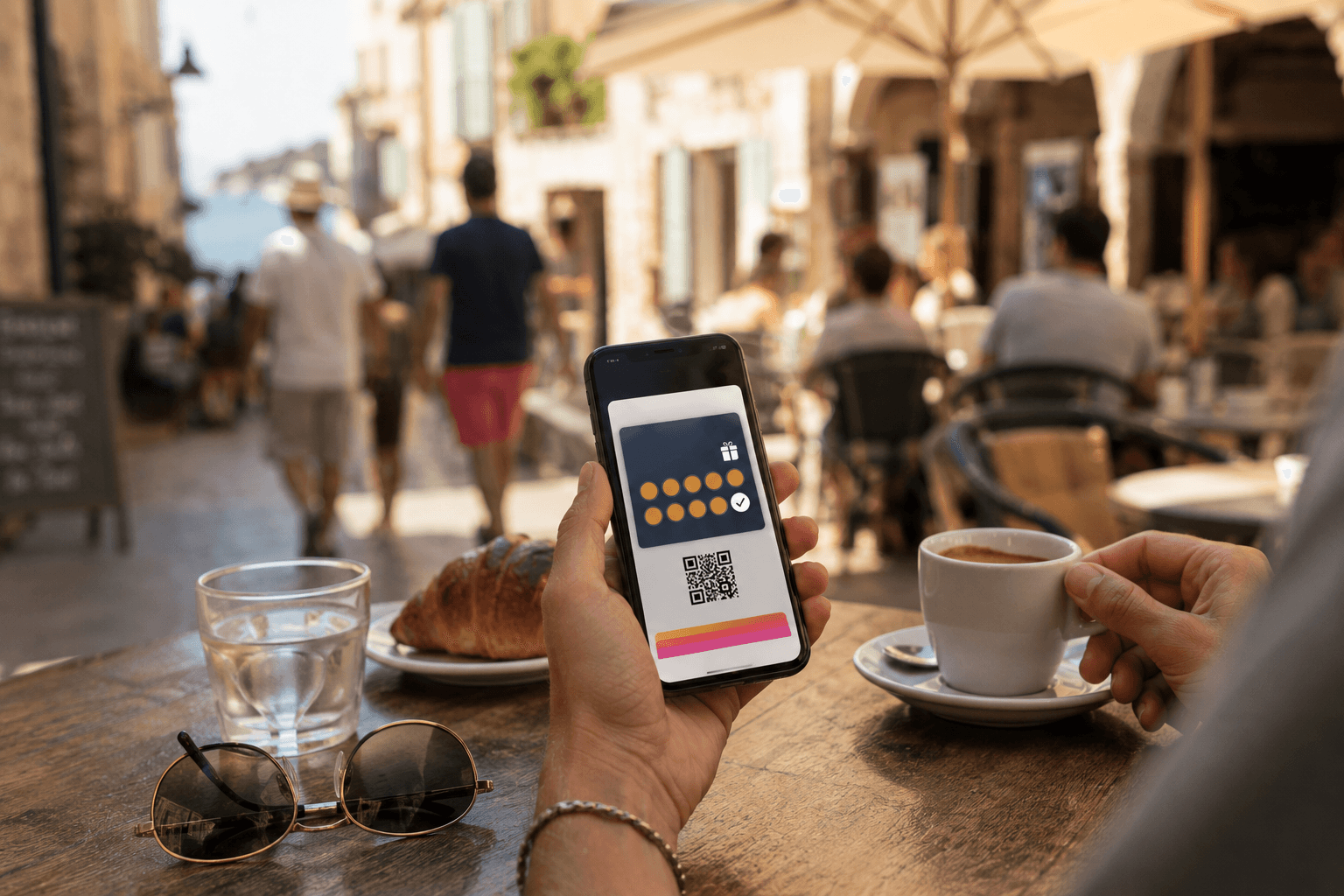 Carte de fidélité affichée dans un téléphone, en terrasse d'un café en vacances