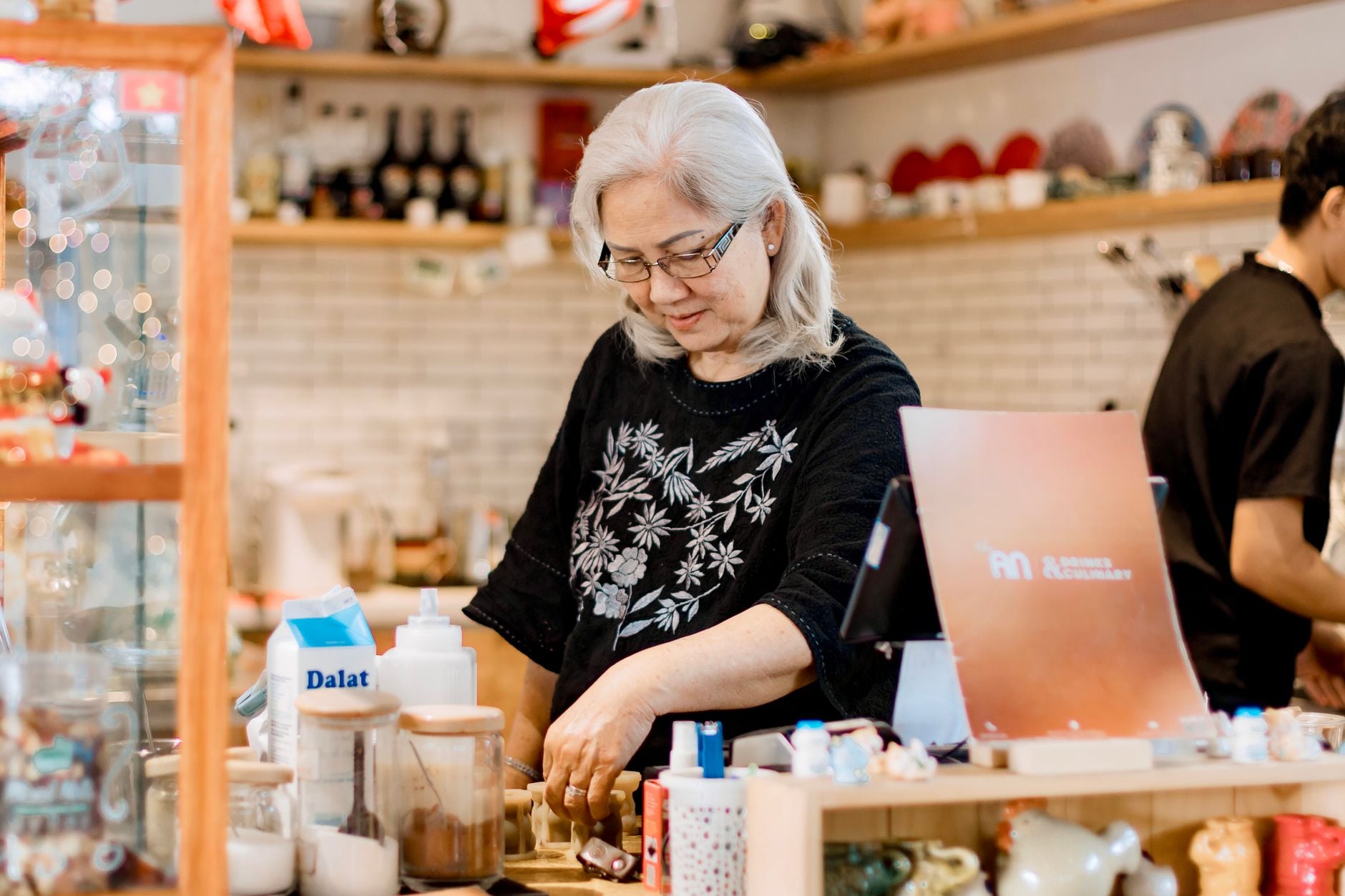 Commerçante derrière le comptoir de son café de quartier